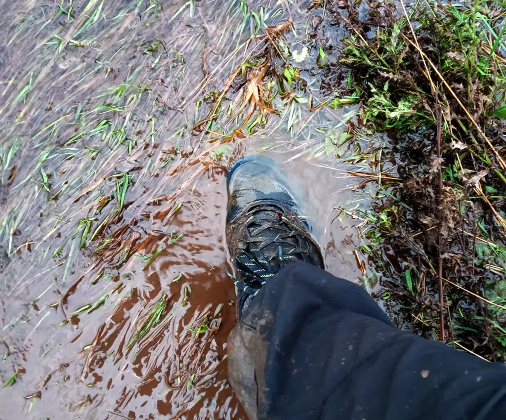 Walking through a waterlogged field in walking boots