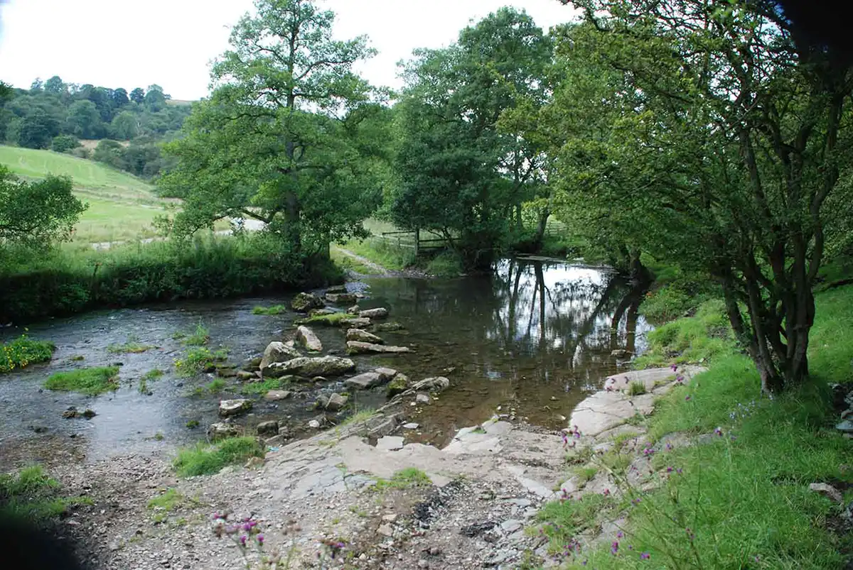 Stepping stones cross the River Dove where a track fords the river at a shallow point