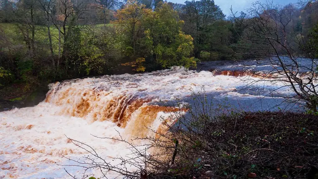 Water rushes over rocks at Aysgarth Middle Force waterfall